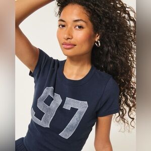 NEW WITH TAGS!!! Hollister Navy Blue “97” Graphic Baby Tee Size Small